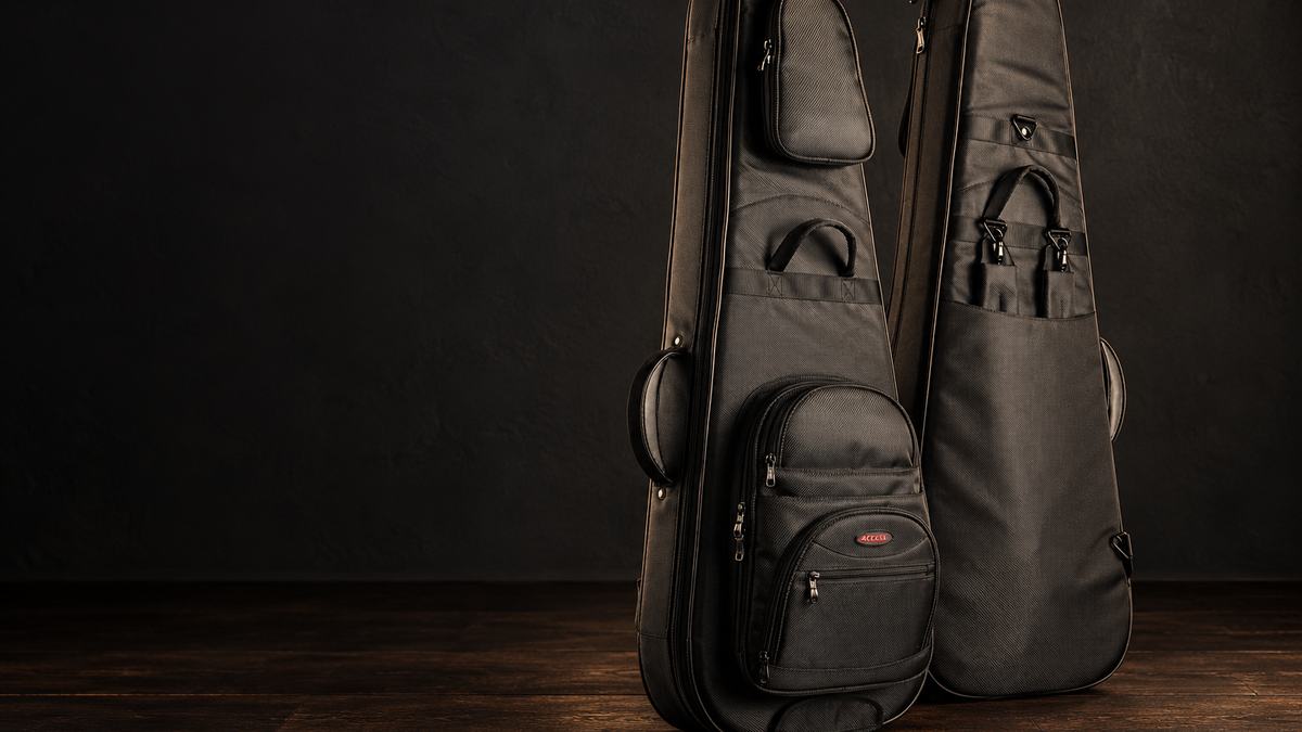 Two padded gig bags standing on a wooden studio floor